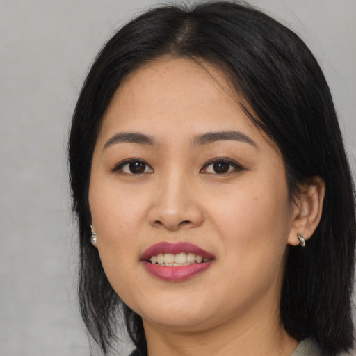 Joyful asian young-adult female with long  black hair and brown eyes