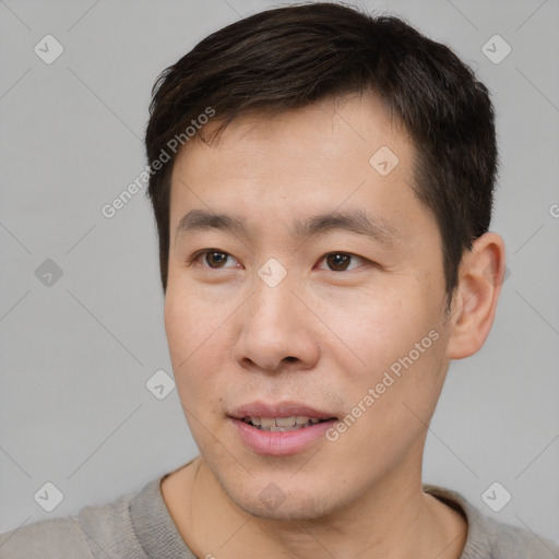 Joyful asian young-adult male with short  brown hair and brown eyes