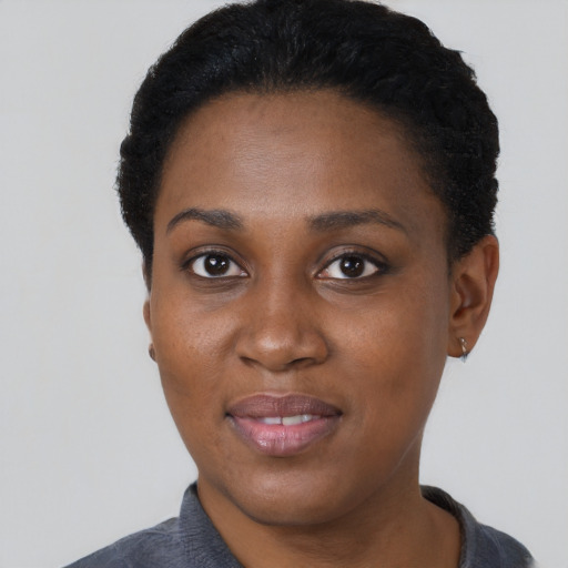 Joyful black young-adult female with short  black hair and brown eyes