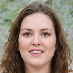 Joyful white young-adult female with long  brown hair and green eyes