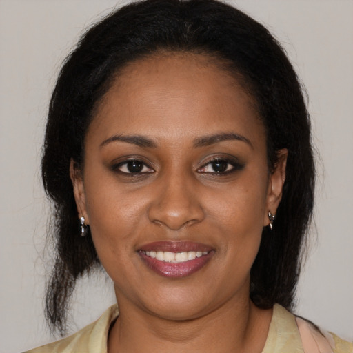 Joyful black young-adult female with medium  brown hair and brown eyes