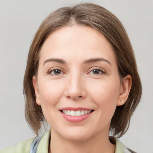 Joyful white young-adult female with medium  brown hair and grey eyes