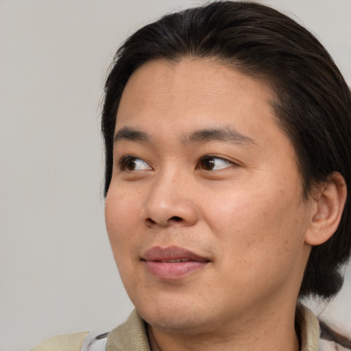 Joyful asian young-adult male with medium  brown hair and brown eyes