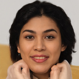 Joyful latino young-adult female with long  brown hair and brown eyes