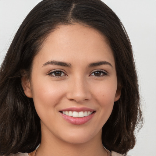 Joyful white young-adult female with long  brown hair and brown eyes