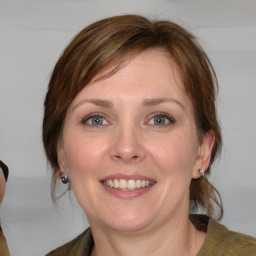 Joyful white adult female with medium  brown hair and blue eyes