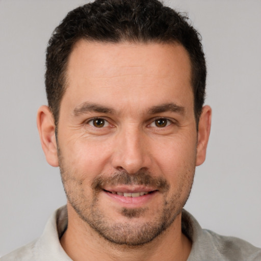 Joyful white young-adult male with short  brown hair and brown eyes