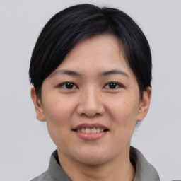 Joyful asian young-adult female with short  brown hair and brown eyes