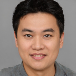 Joyful asian young-adult male with short  brown hair and brown eyes