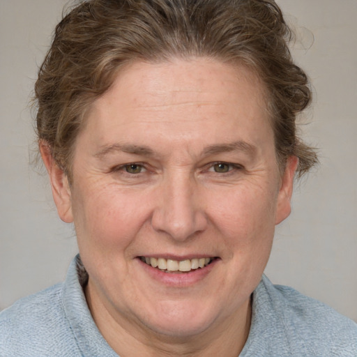 Joyful white adult female with short  brown hair and blue eyes