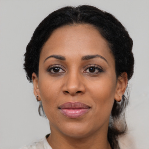 Joyful latino adult female with medium  black hair and brown eyes