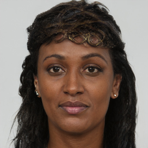 Joyful black young-adult female with long  brown hair and brown eyes
