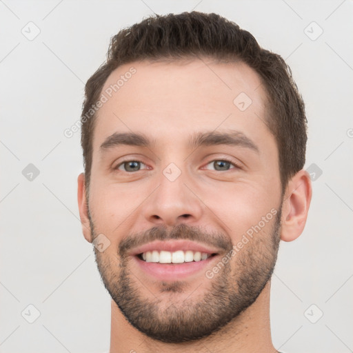 Joyful white young-adult male with short  brown hair and brown eyes