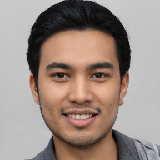 Joyful asian young-adult male with short  black hair and brown eyes