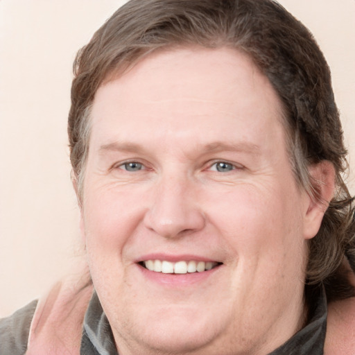 Joyful white adult male with medium  brown hair and blue eyes