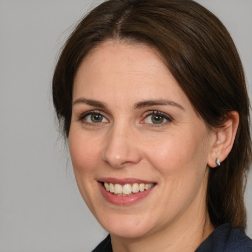 Joyful white adult female with medium  brown hair and brown eyes