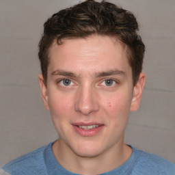 Joyful white young-adult male with short  brown hair and blue eyes