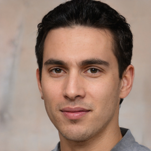 Joyful white young-adult male with short  black hair and brown eyes