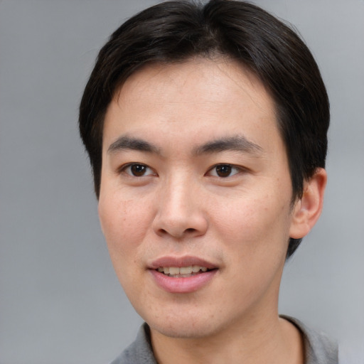 Joyful asian young-adult male with short  brown hair and brown eyes
