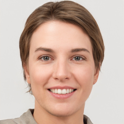 Joyful white young-adult female with short  brown hair and grey eyes