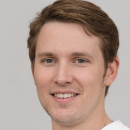 Joyful white young-adult male with short  brown hair and grey eyes