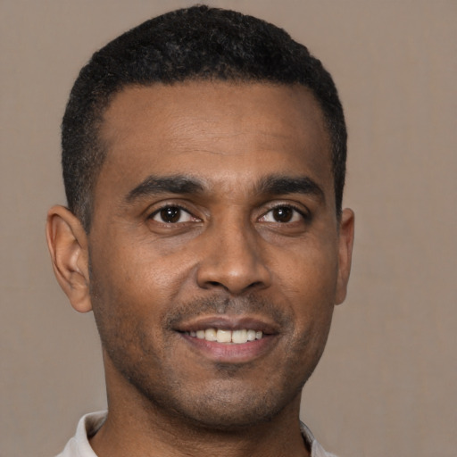 Joyful black young-adult male with short  brown hair and brown eyes