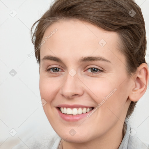 Joyful white young-adult female with short  brown hair and grey eyes