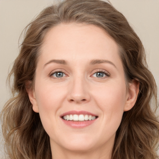 Joyful white young-adult female with long  brown hair and grey eyes