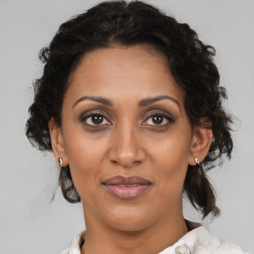 Joyful black adult female with medium  brown hair and brown eyes