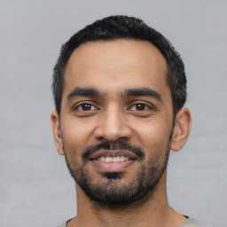 Joyful latino young-adult male with short  black hair and brown eyes