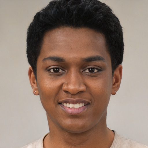 Joyful black young-adult male with short  black hair and brown eyes