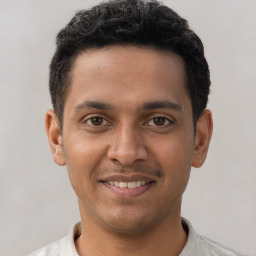 Joyful latino young-adult male with short  brown hair and brown eyes