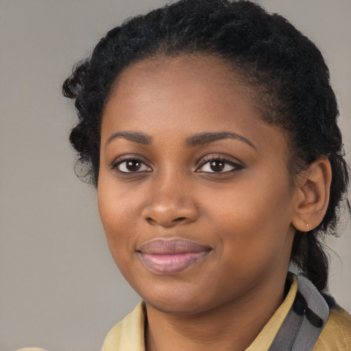 Joyful black young-adult female with long  brown hair and brown eyes