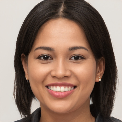 Joyful latino young-adult female with long  brown hair and brown eyes