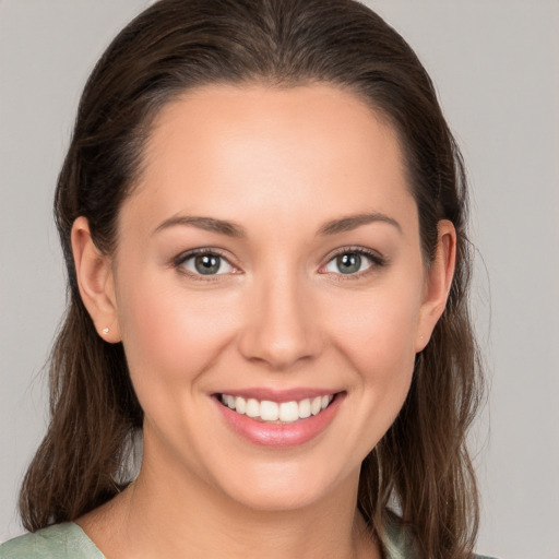 Joyful white young-adult female with medium  brown hair and grey eyes