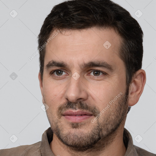 Joyful white young-adult male with short  black hair and brown eyes