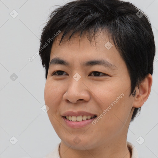 Joyful asian young-adult male with short  brown hair and brown eyes