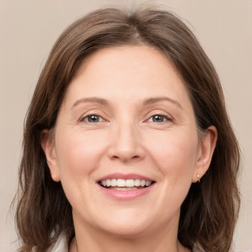 Joyful white adult female with medium  brown hair and grey eyes