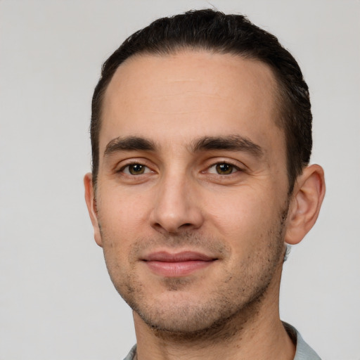 Joyful white young-adult male with short  black hair and brown eyes