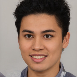 Joyful latino young-adult male with short  brown hair and brown eyes