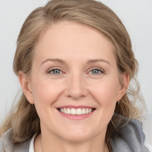 Joyful white adult female with medium  brown hair and blue eyes