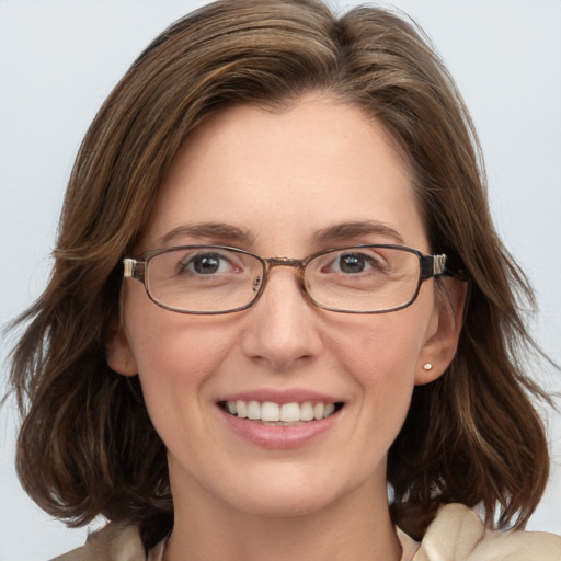 Joyful white adult female with medium  brown hair and blue eyes