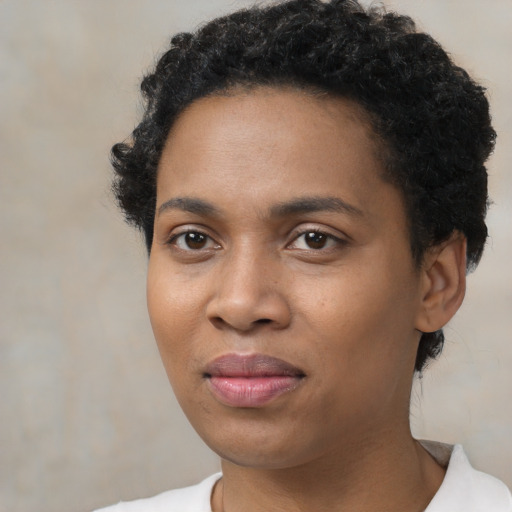 Joyful black young-adult female with short  black hair and brown eyes
