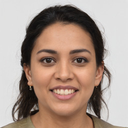 Joyful latino young-adult female with medium  brown hair and brown eyes