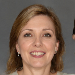 Joyful white adult female with medium  brown hair and blue eyes