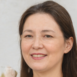 Joyful white adult female with long  brown hair and brown eyes