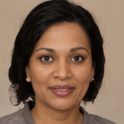 Joyful black adult female with medium  brown hair and brown eyes