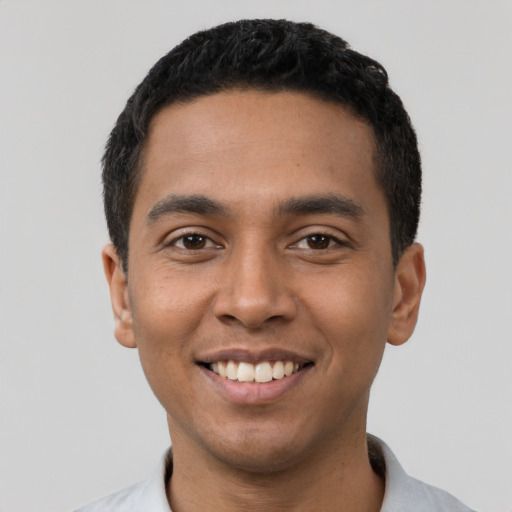 Joyful latino young-adult male with short  black hair and brown eyes