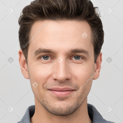 Joyful white young-adult male with short  brown hair and grey eyes