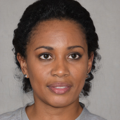 Joyful black young-adult female with medium  black hair and brown eyes